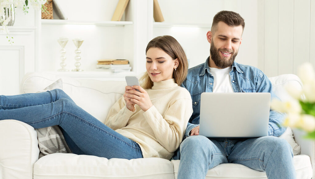 Uomo e donna giocano a un solitario su dispositivi diversi